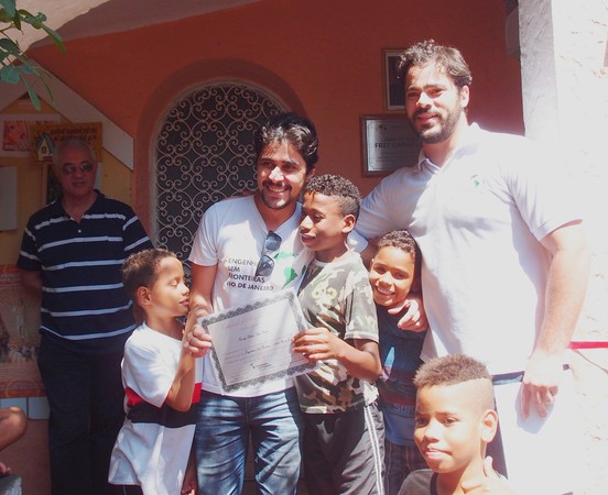 João Henrique, coordenador do projeto, e Fanuty, entre as crianças. Ao fundo, Sr. Roberto, diretor do abrigo 