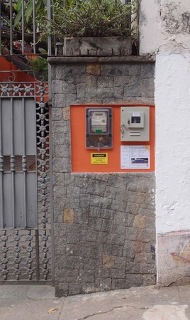 Do lado de fora do muro, o medidor bidirecional e, na caixa cinza, a chave DSV que é obsoleta desde abril de 2014.